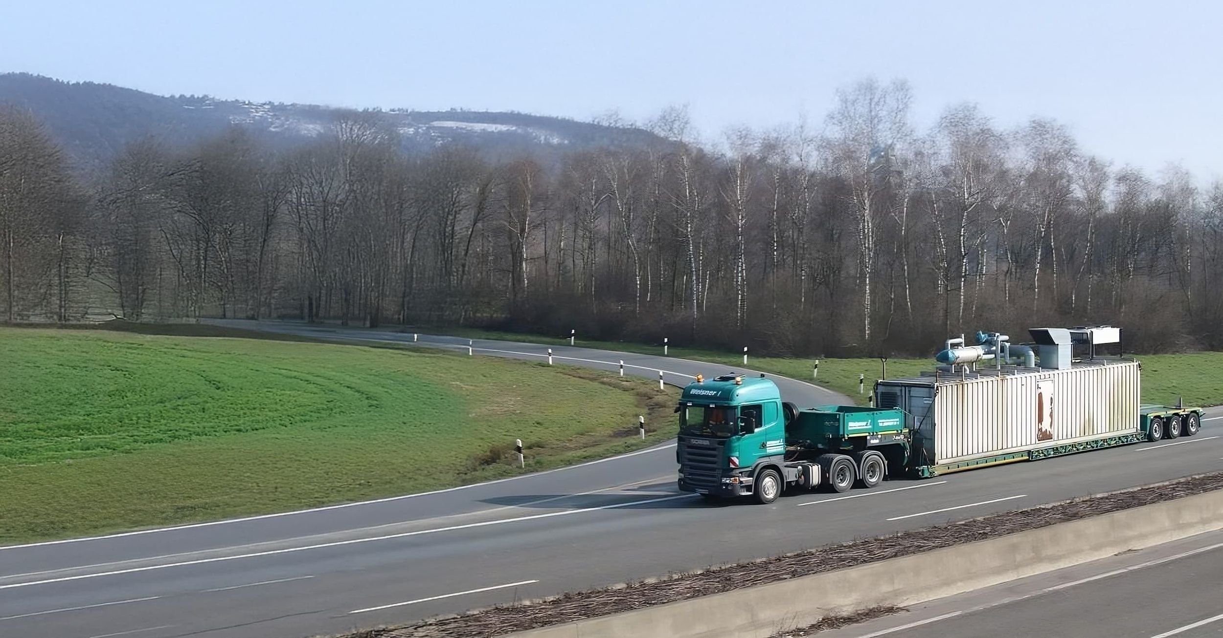 Ein LKW der Ruth Weisner GmbH transportiert einen Container über eine Autobahn.